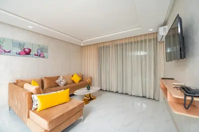 a living room with a couch and a television at maarif elite suite in Casablanca