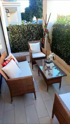 a patio with wicker chairs and a coffee table at Idéal séjour Cozy aprt bouznika piscine et plage in Bouznika