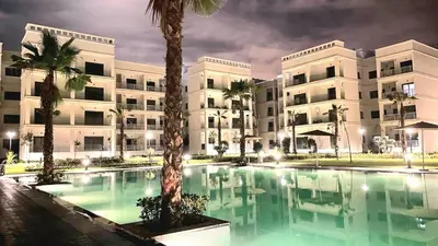 a large building with a swimming pool in front of a building at Idéal séjour Cozy aprt bouznika piscine et plage in Bouznika