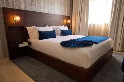 a bedroom with a large bed with a blue bow on it at Fourteen Hotel Ain Sebaa in Casablanca