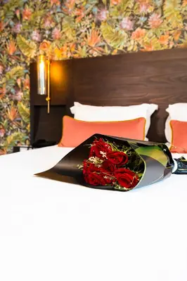 a tray of red roses sitting on a bed at Fourteen Hotel Ain Sebaa in Casablanca