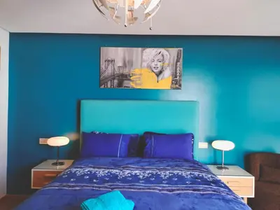 a blue bedroom with a bed with a blue wall at Panoramic View from 14th floor in Casablanca