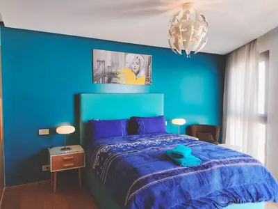 a blue bedroom with a bed and a blue wall at Panoramic View from 14th floor in Casablanca
