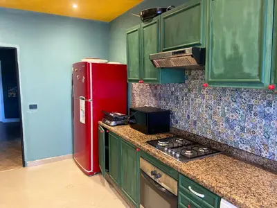 a kitchen with green cabinets and a red refrigerator at Loft51 in Casablanca
