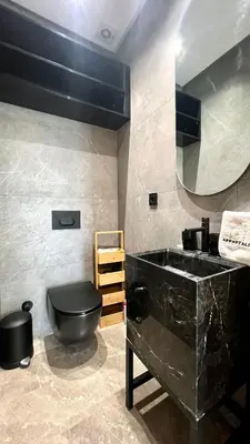 a bathroom with a black toilet and a sink at The Address - Sunny Anfa Hills in Casablanca