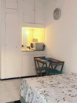 a room with a microwave and a table and a bed at Mi mini estudio 1 in Rabat
