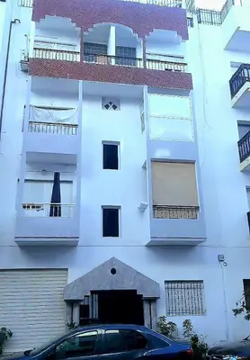 a white building with a car parked in front of it at Mi mini estudio 1 in Rabat