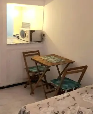 a table with two chairs and a microwave in a room at Mi mini estudio 1 in Rabat