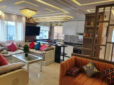 a living room with couches and a kitchen at Grand Appartement corniche in Casablanca