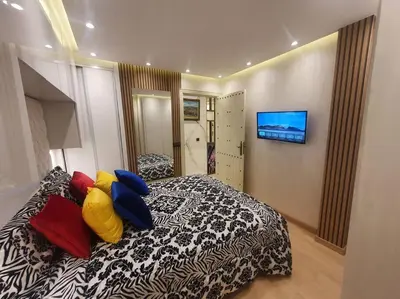 a bedroom with a bed with colorful pillows on it at Grand Appartement corniche in Casablanca