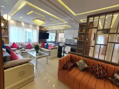 a large living room with couches and a kitchen at Grand Appartement corniche in Casablanca