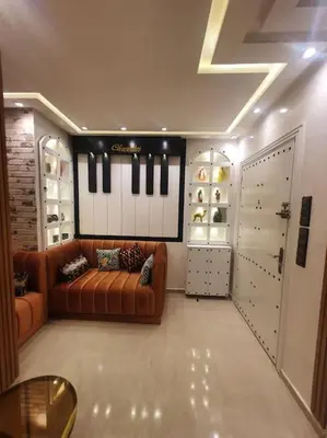 a living room with a couch and a table and a door at Grand Appartement corniche in Casablanca