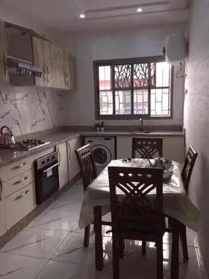 a kitchen with a table and chairs and a stove at Airport M V chambre stay in Deroua