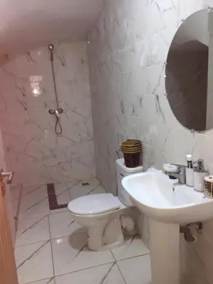 a white bathroom with a toilet and a sink at Airport M V chambre stay in Deroua