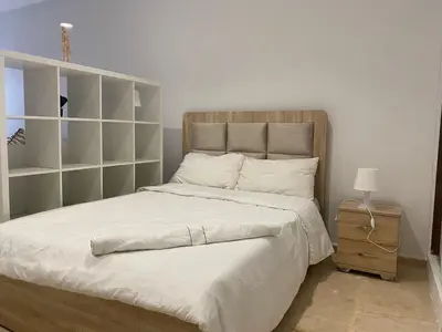 a bedroom with a bed with white sheets and a nightstand at Quiet Top-Floor Studio by Med Faculty & Tram Lines in Casablanca