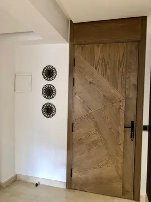 a wooden door in a room with a wall at Chic Palmier - heart of town in Casablanca