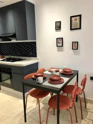 a kitchen with a table with four chairs and a stove at Chic Palmier - heart of town in Casablanca