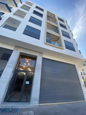 a large white building with a garage door at Chic Palmier - heart of town in Casablanca