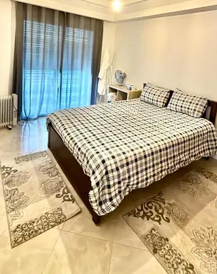 a bedroom with a bed with a checkered blanket at Camilia Appart 2P TGV in Rabat