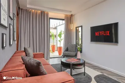 a living room with a couch and a tv at Stayhere Rabat - Agdal 4 - Hotel in Rabat