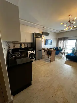 a kitchen and living room with a stove and refrigerator at Appartement confortable et pas cher au parc in Mohammedia