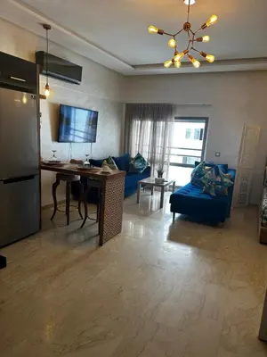 a living room with a blue couch and a table at Appartement confortable et pas cher au parc in Mohammedia