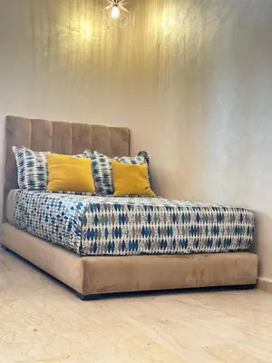 a couch with two pillows on it in a room at Appartement confortable et pas cher au parc in Mohammedia