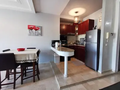 a kitchen with a table and a refrigerator at Blume Apartment Casa Port - 2 Bedrooms in Casablanca