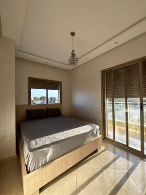 a bedroom with a bed and a large window at Apparemment de luxe Bouznika in Bouznika