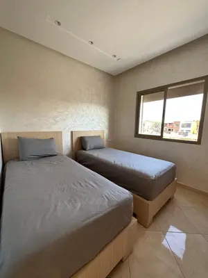 a bedroom with two beds and a window at Apparemment de luxe Bouznika in Bouznika