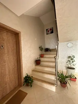 a hallway with stairs with potted plants and a door at Apparemment de luxe Bouznika in Bouznika