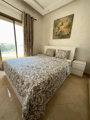 a bedroom with a bed and a painting on the wall at Apparemment de luxe Bouznika in Bouznika