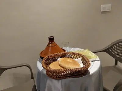 a basket of bread on a table with a vase at Beautiful apartment next to airport Mohamed V in Derroua