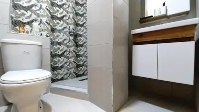 a bathroom with a white toilet and a shower at Beautiful apartment next to airport Mohamed V in Derroua