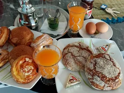 a table topped with plates of pastries and glasses of orange juice at Beautiful apartment next to airport Mohamed V in Derroua