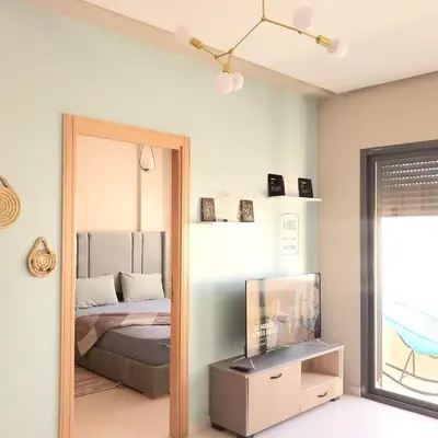 a bedroom with a mirror and a bed and a tv at appartement moderne proche aéroport in Derroua