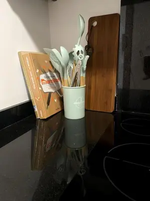 a cup of utensils on a table next to a box at Jade - Appartement Luxe - Casablanca in Casablanca