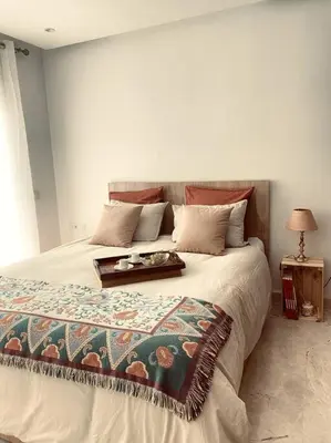 a bedroom with a large bed with a table on it at Jade - Appartement Luxe - Casablanca in Casablanca