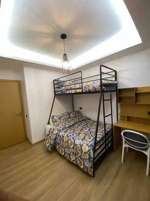 a bedroom with a bunk bed and a desk at Belle appartement à découvrir in El Harhoura