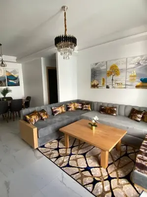 a living room with a couch and a table at Belle appartement à découvrir in El Harhoura