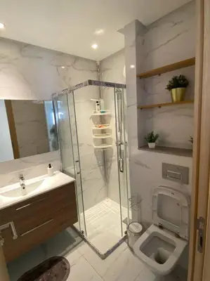 a bathroom with a shower and a toilet and a sink at Belle appartement à découvrir in El Harhoura