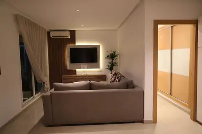 a living room with a couch and a flat screen tv at Cozy Apartment with Veranda Downtown in Casablanca