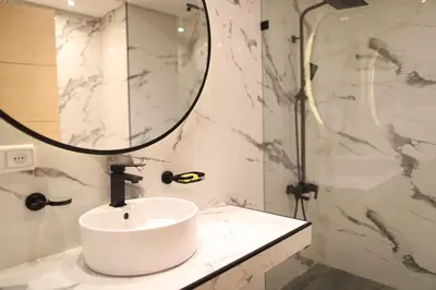 a white bathroom with a sink and a shower at Cozy Apartment with Veranda Downtown in Casablanca