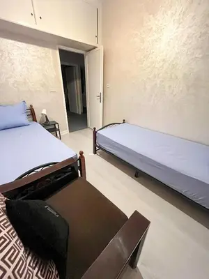 a bedroom with two beds and a bench in it at L'Appartement Harmonia Cozy in Casablanca