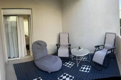 a living room with two chairs and a table and a table and chairsktop at Vague Bleue chez Makuja Home in Bouznika