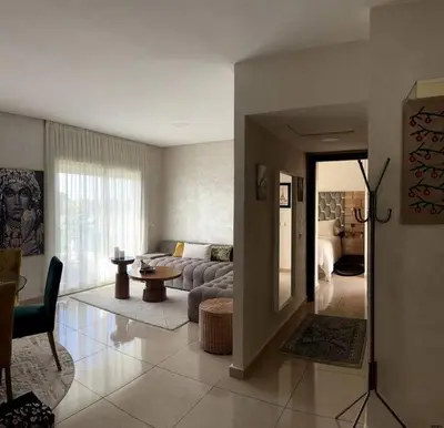 a living room with a couch and a table at Vague Bleue chez Makuja Home in Bouznika