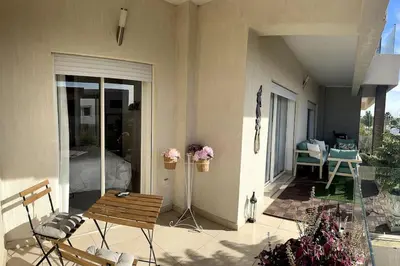 a patio with a bench and a table and chairs at Vague Bleue chez Makuja Home in Bouznika