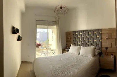 a bedroom with a large white bed and a window at Vague Bleue chez Makuja Home in Bouznika