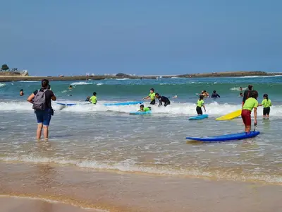 a group of people on the beach with surfboards at Résidence de vacances vue piscine plages Mimosas Sablettes in Mohammedia