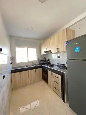 a kitchen with wooden cabinets and a stainless steel refrigerator at Lovely 2 bedroom apartment in Rabat